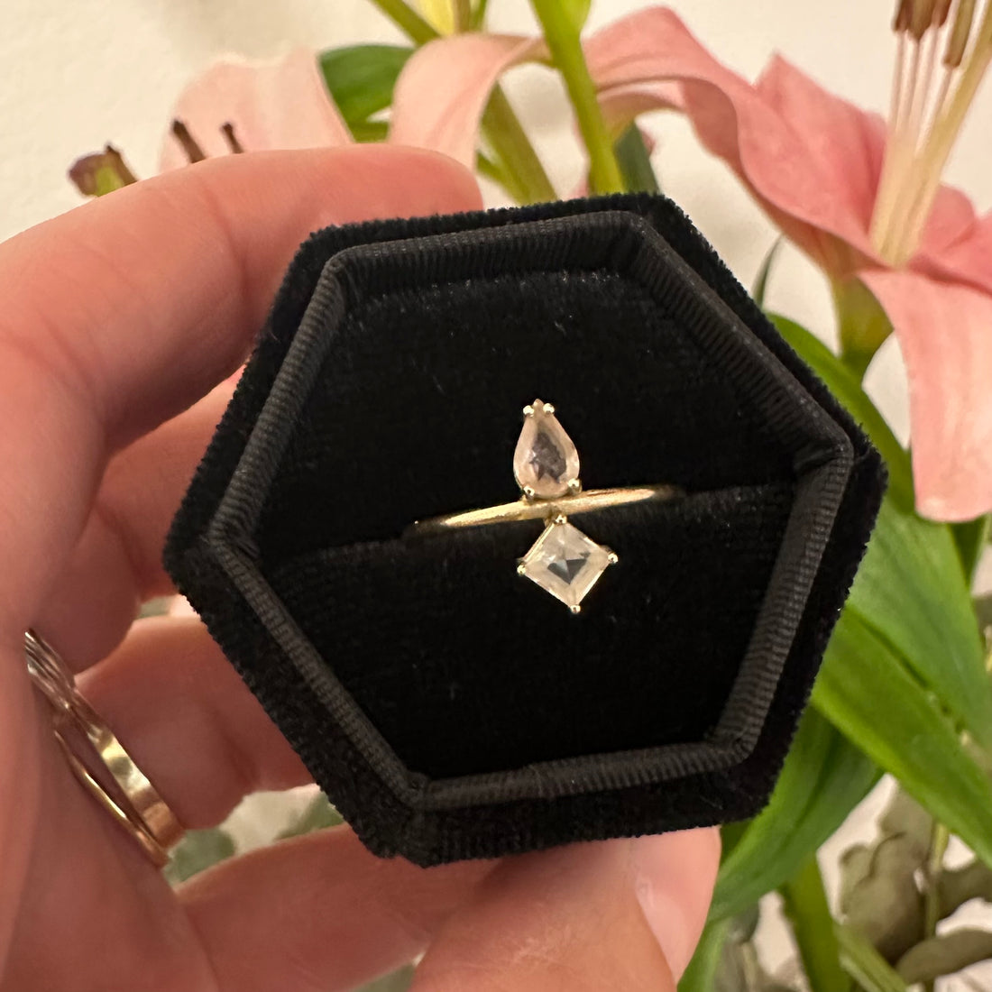 Gold ring with two gemstones on a white background