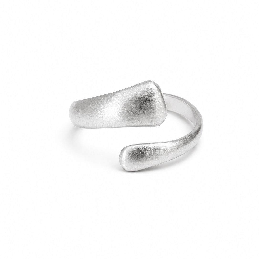 A minimalist silver open-bend ring with a textured, organic matte finish, photographed on a seamless white background.