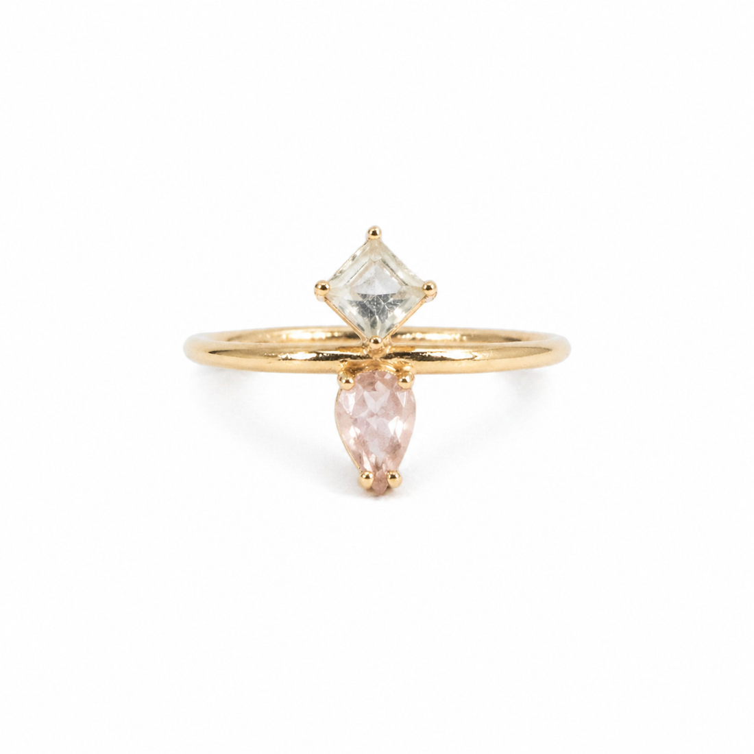 Gold ring with two gemstones on a white background