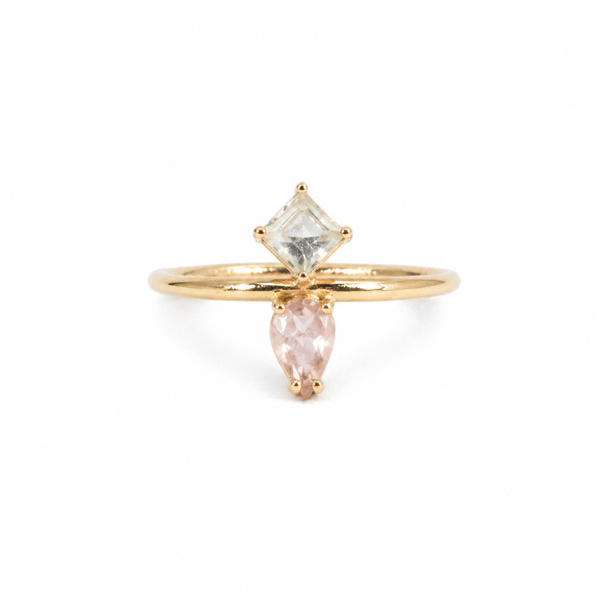 Gold ring with two gemstones on a white background