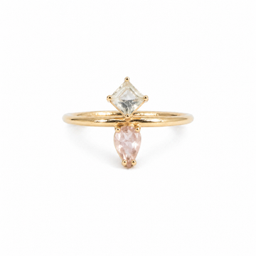 Gold ring with two gemstones on a white background