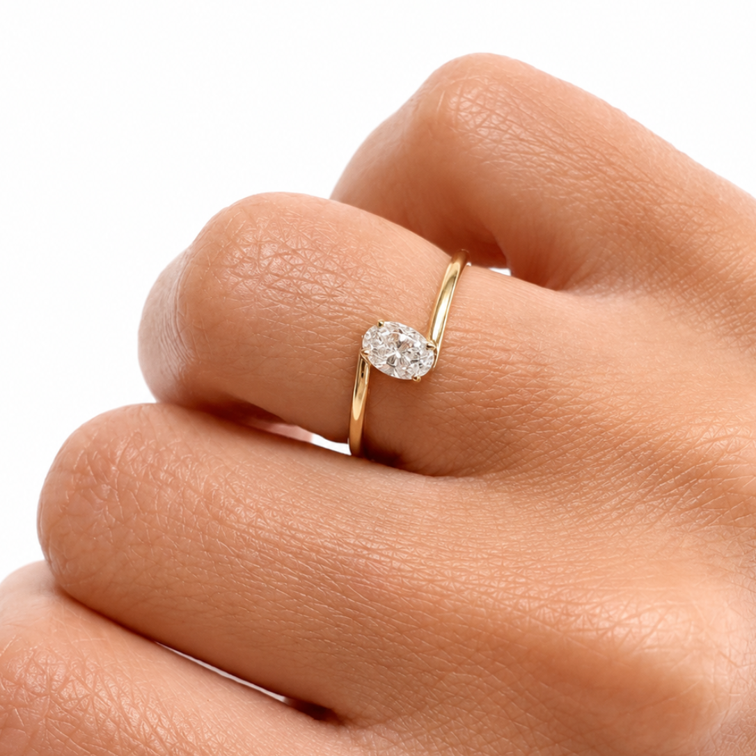 Gold ring with a diamond on a hand against a white background