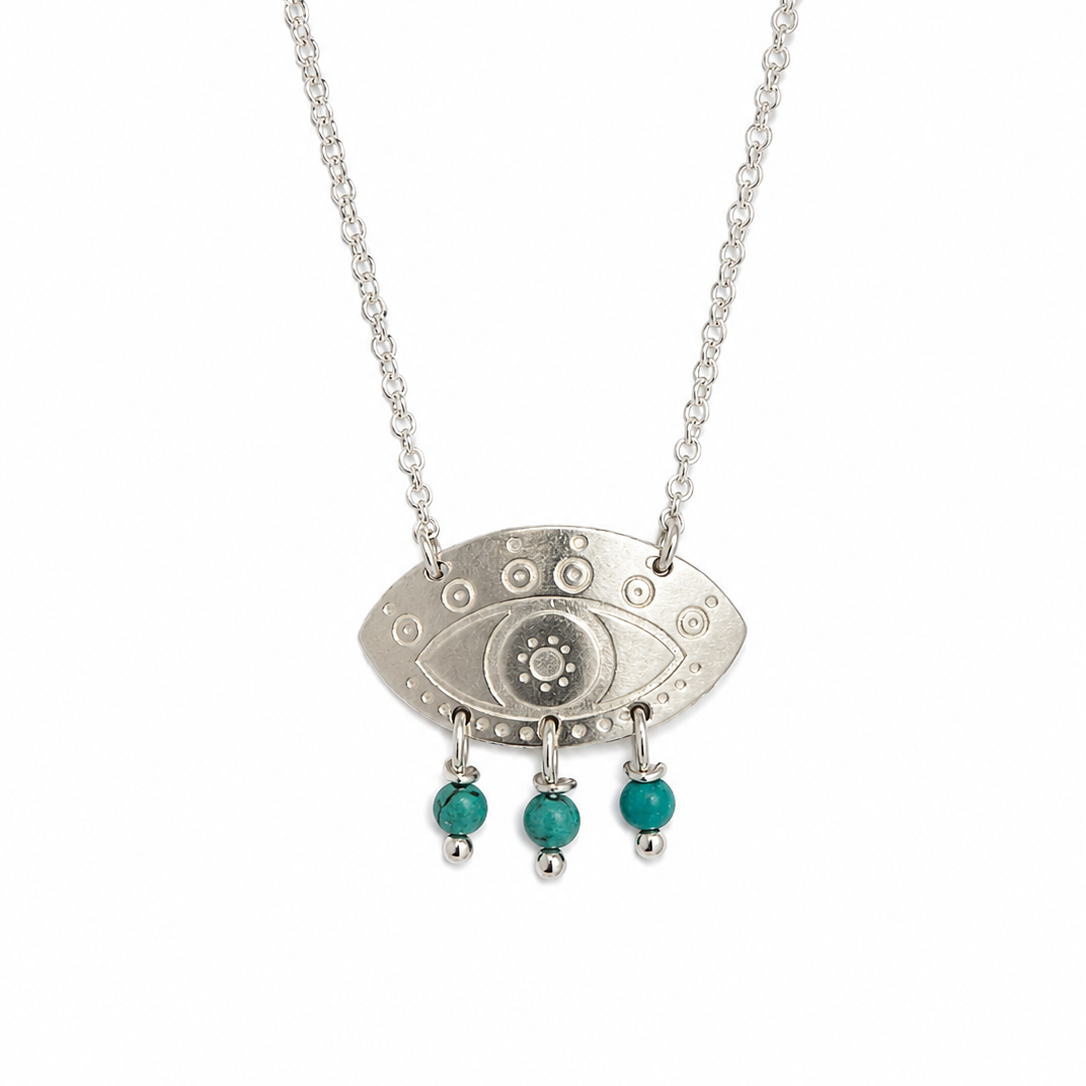 Silver necklace with an eye-shaped pendant and turquoise beads on a white background