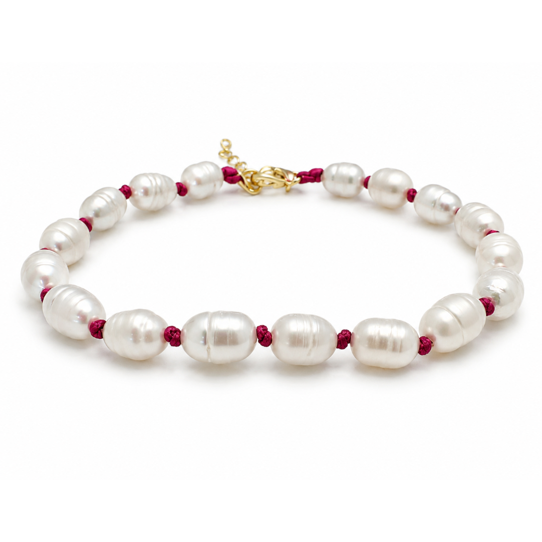 Pearl bracelet with red beads on a white background