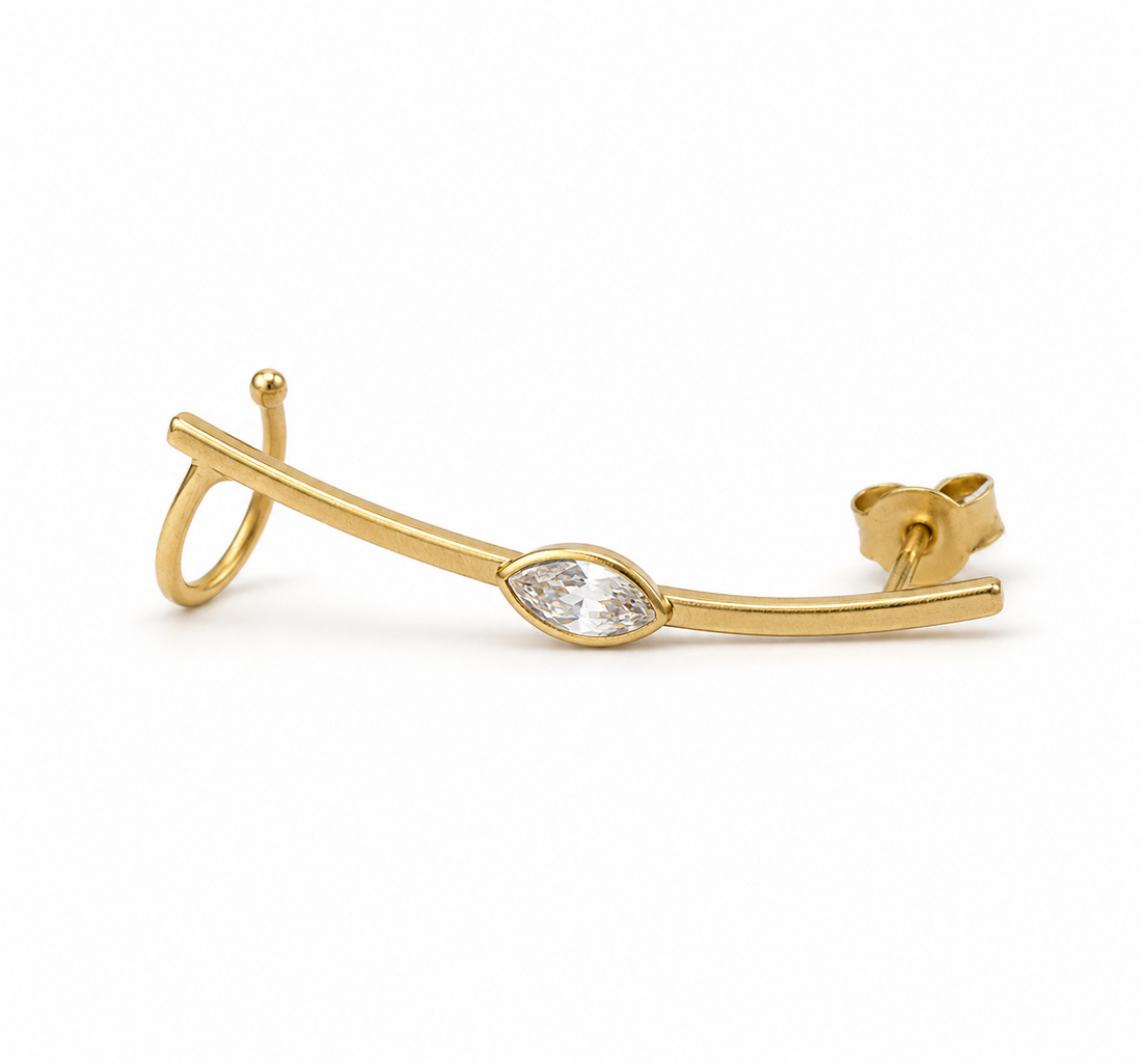 Gold earring with a zirgon on a white background