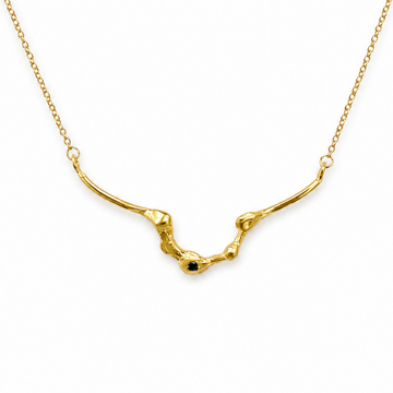 A gold necklace featuring a textured, organic-shaped pendant with a small dark blue gemstone accent at the center, displayed on a clean white background.
