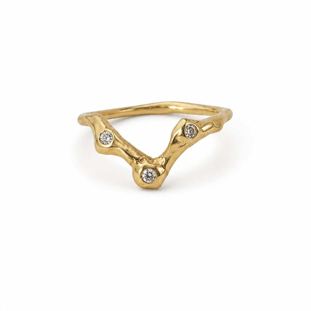 Gold ring with diamond accents on a white background