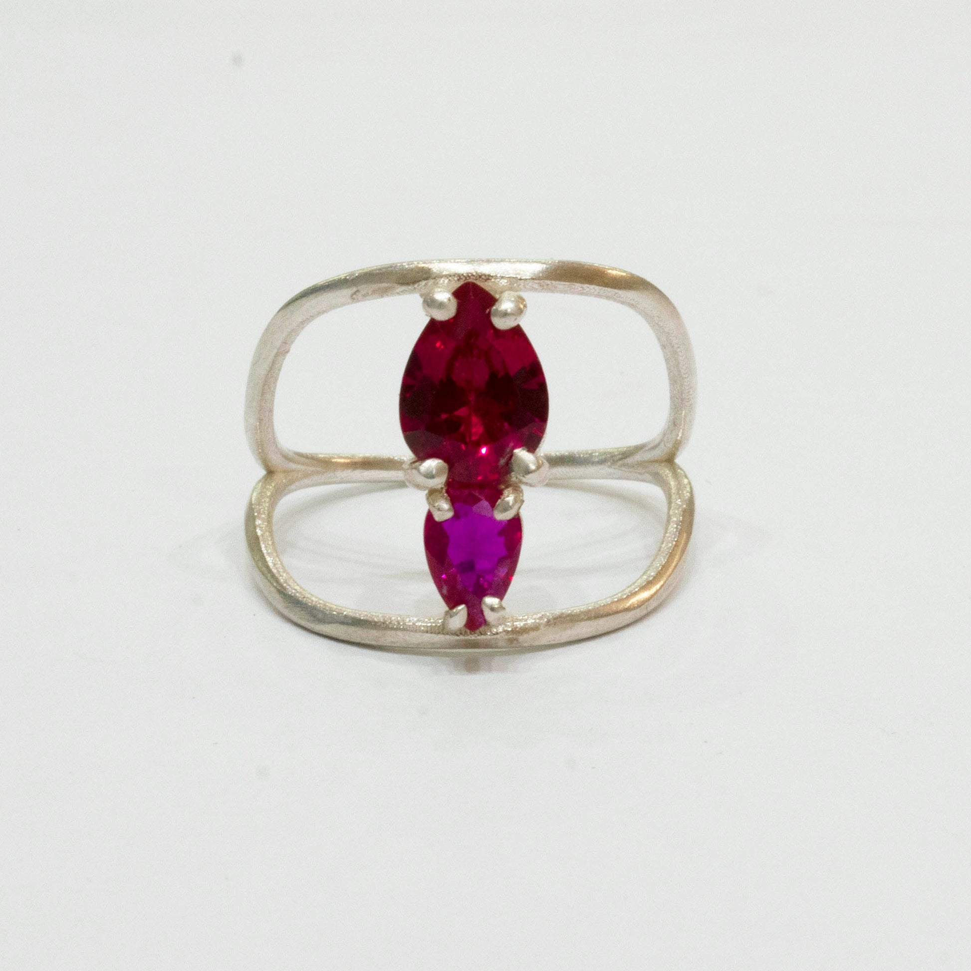 Silver ring with a marquise-shaped red gemstone on a white background