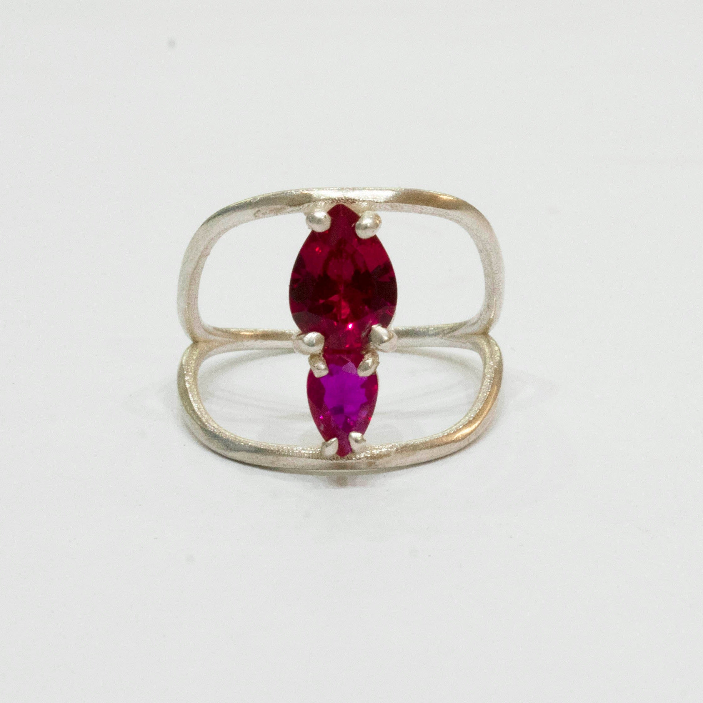 Silver ring with a marquise-shaped red gemstone on a white background