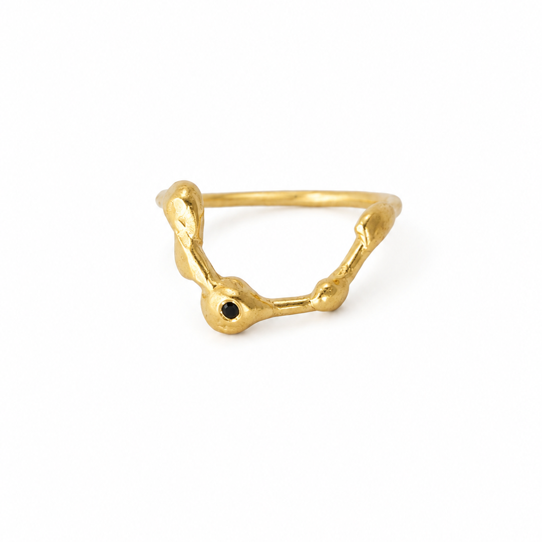 Gold ring with a black gemstone on a white background