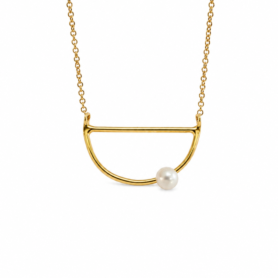 A gold necklace featuring a minimalist semi-circular open pendant with a single white pearl accent, shown against a plain white background.