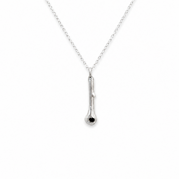 A delicate silver chain necklace featuring a small, polished silver pendant with a single tiny black gemstone accent at the bottom, shown against a plain white background.