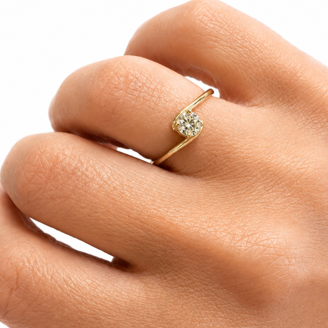 Gold ring with a diamond on a hand against a white background