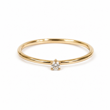 Gold ring with a tiny  diamond on a white background