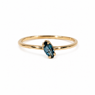Gold ring with a  london blue  topaz gemstone on a white background