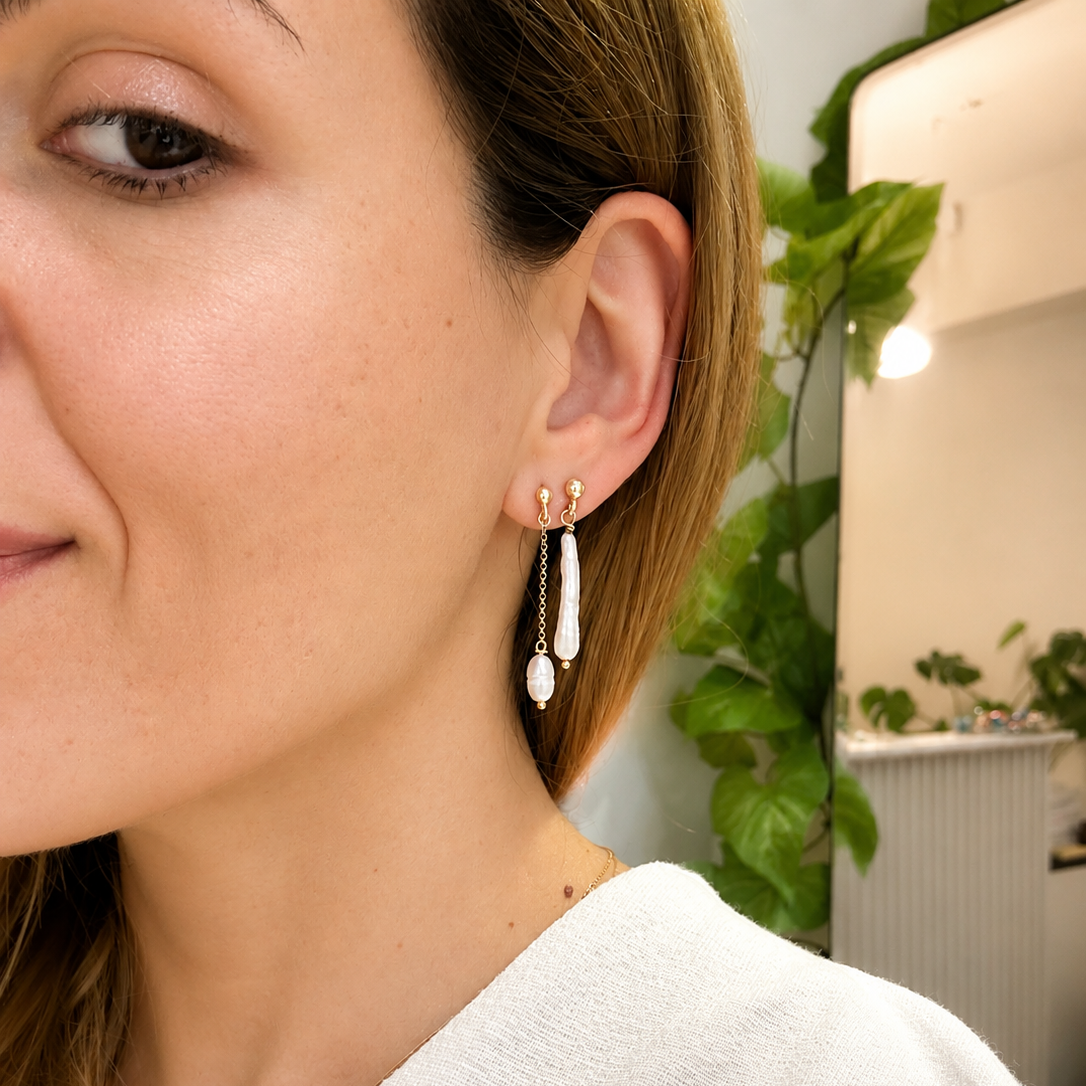 Close-up of a woman wearing gold earrings with a blurred indoor background