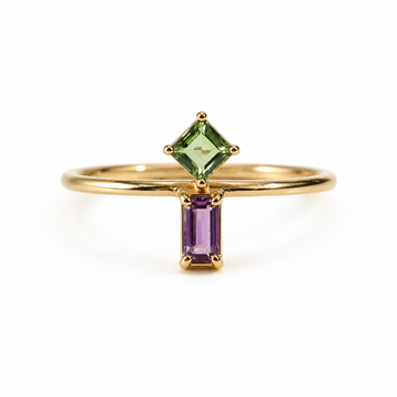 Gold ring with green and purple gemstones on a white background